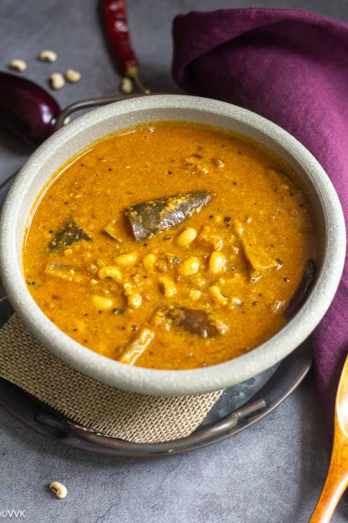 close up shot of brinjal and cow peas gravy served in white ceramic ware
