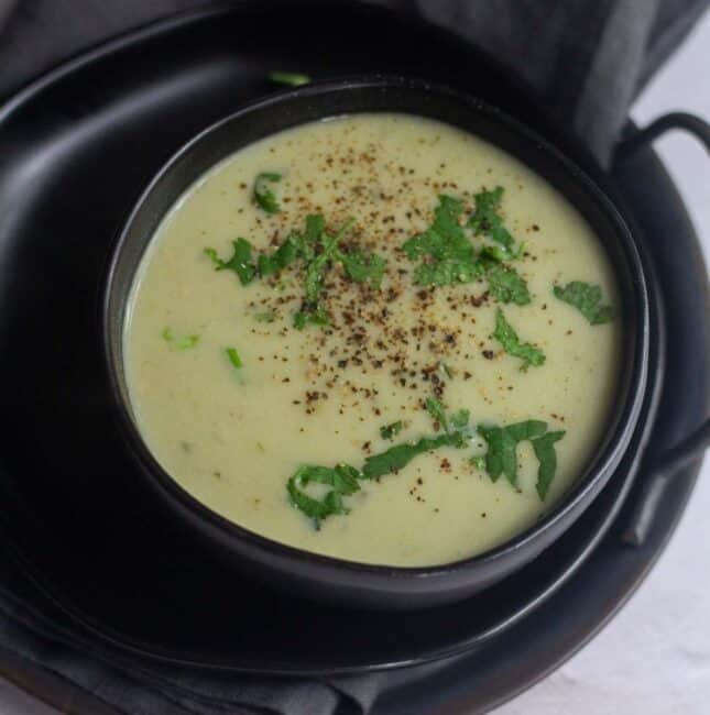 square image of bottle gourd soup served in black bowl